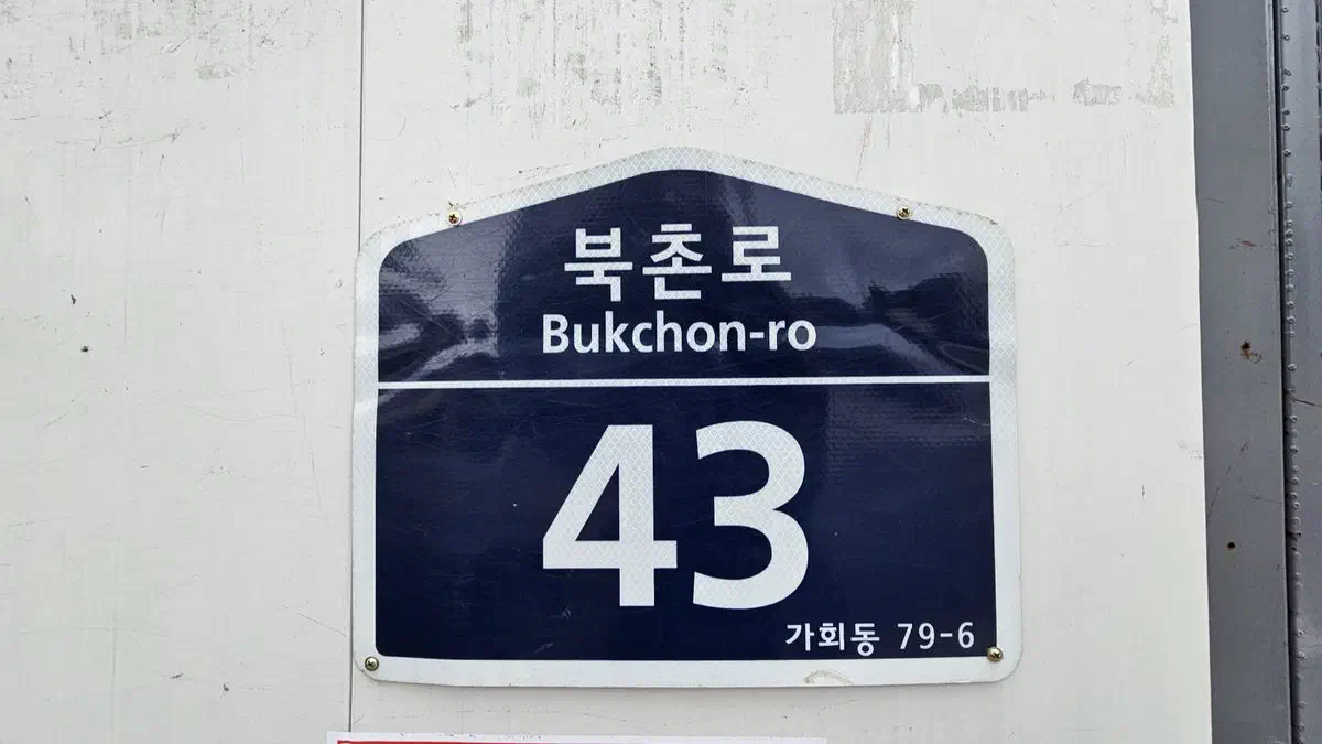 A Bukchon-ro building address plate reading number 43, with the older lot-number address Gahoe-dong 79-6 printed beneath it