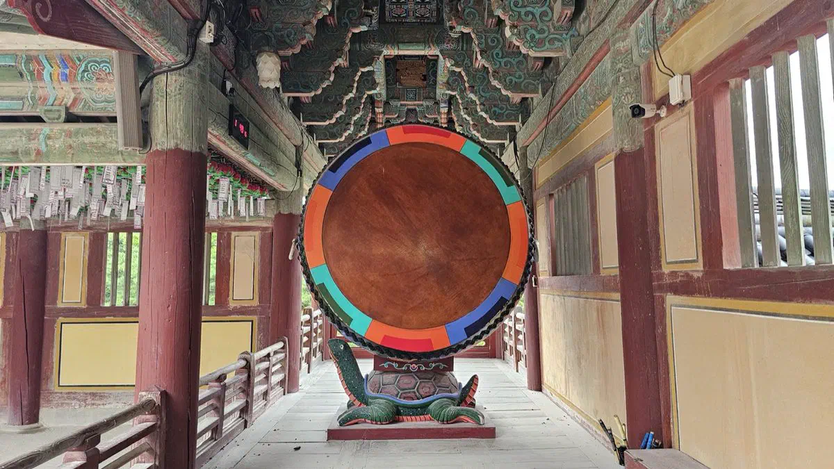A large temple drum at Bulguksa, its rim painted in dancheong colors, standing under the eaves of one of the temple's wooden halls