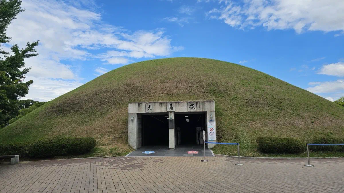 The grass-covered mound of Cheonmachong with its excavated entrance tunnel open to visitors