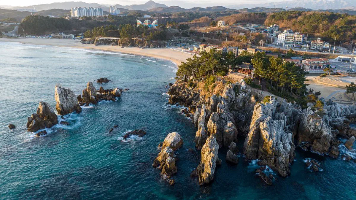 Aerial view of the jagged sea-stack rocks at Chuam, Donghae, rising out of the East Sea beside a small headland temple