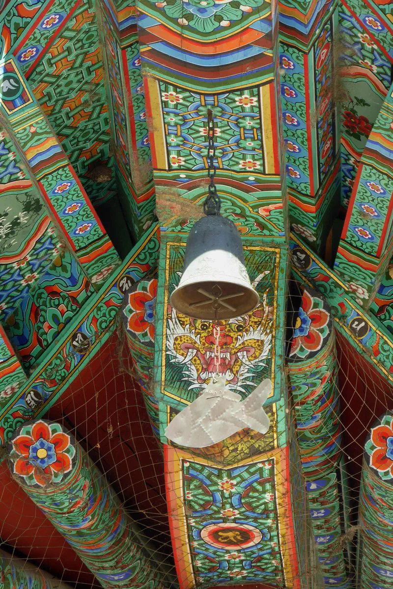 Close detail of dancheong brackets and a bell at the corner of the Jijangjeon hall, Bongeunsa, Seoul