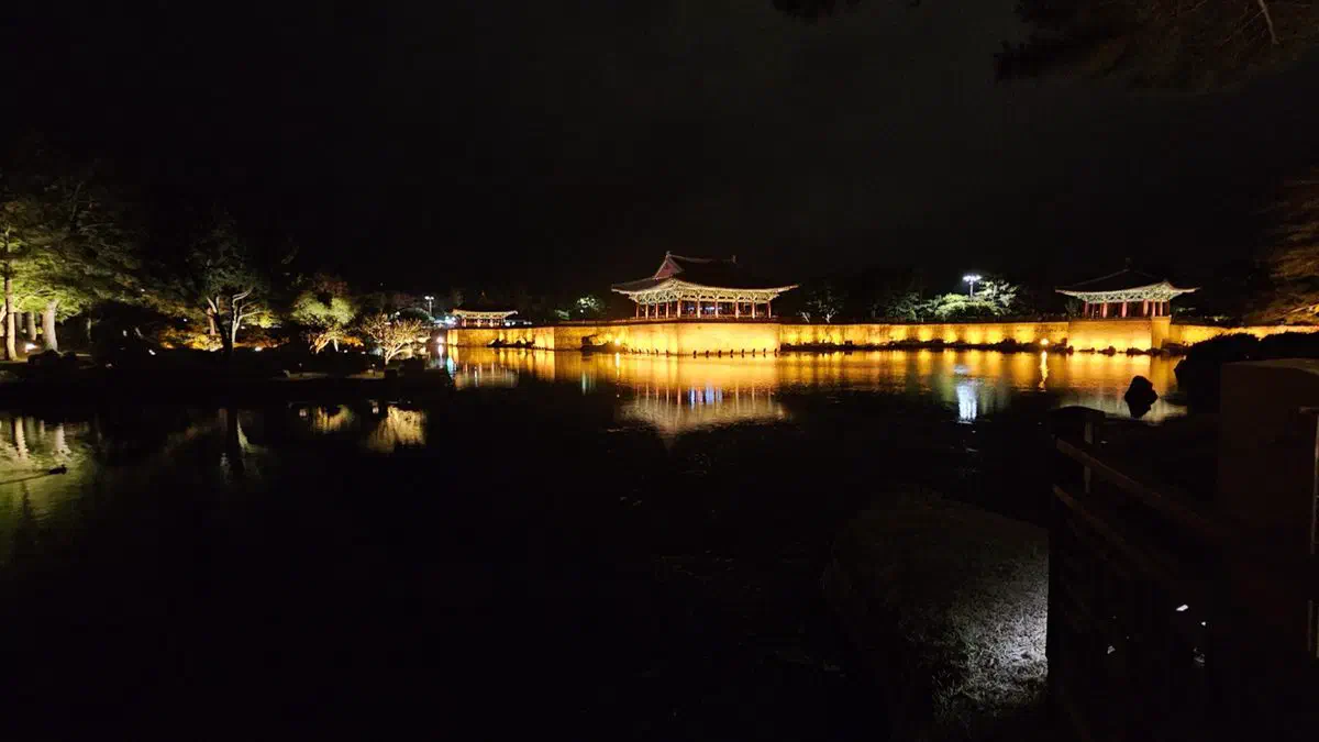Donggung Palace lit at night, its pavilions reflected across Wolji pond