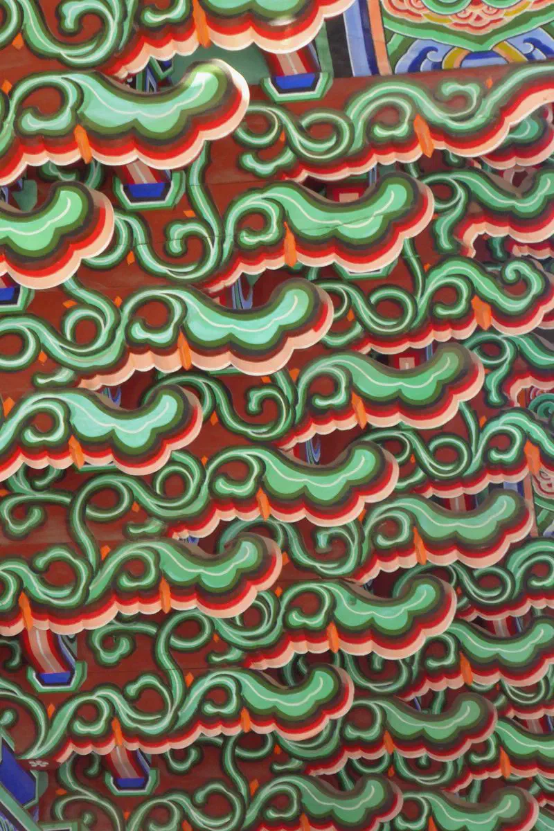 Dancheong ceiling detail in Geunjeongjeon hall at Gyeongbokgung, showing the five obangsaek colors in layered geometric bracketing