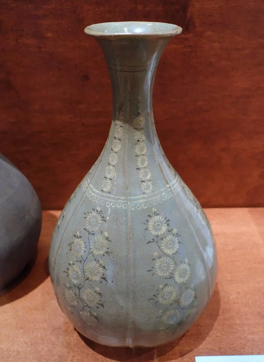 A 13th-century Goryeo celadon bottle with white chrysanthemum patterns set into the jade-green glaze using the sanggam inlay technique