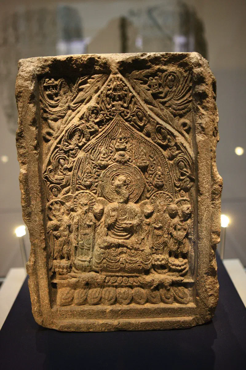 The Gyeyu-inscribed Amitabha Buddha stele at Cheongju National Museum: a rectangular carved stone slab showing a seated Buddha under a pointed canopy, flanked by standing attendants with heavenly figures in the upper corners and a row of lotus petals along the base