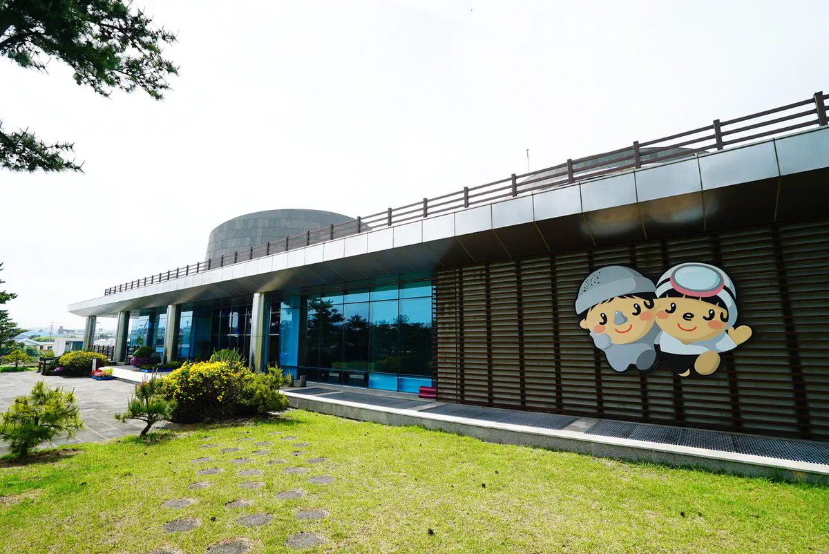 A wall panel on the museum's exterior, two cartoon children in haenyeo diving caps