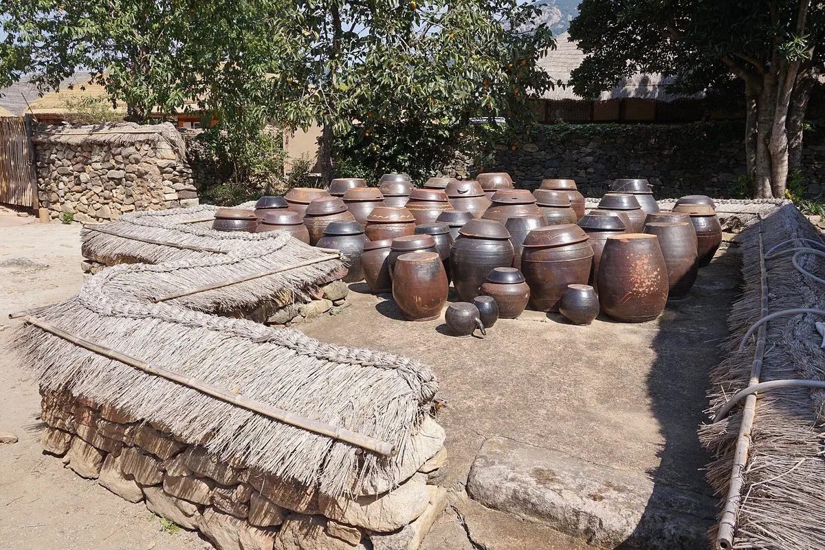 Rows of onggi jars on a raised stone jangdokdae platform in Naganeupseong Folk Village, Suncheon