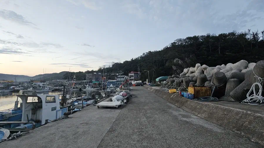 A boat docked beside a stone breakwater at a Gyeongju fishing harbor