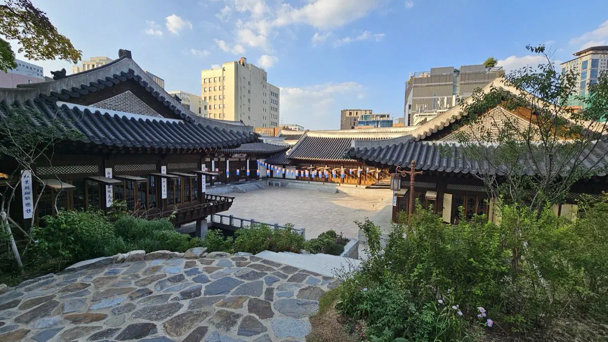 Looking down on the courtyard of Korea House, hanok roofs on both sides and apartment blocks beyond