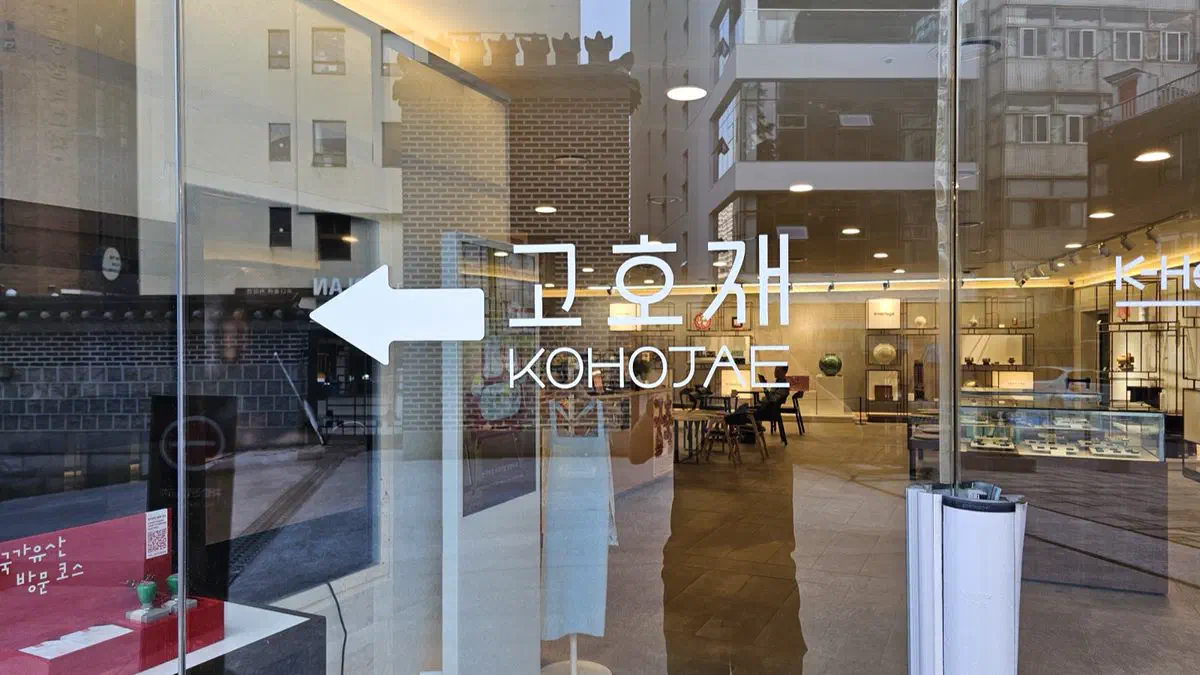 Glass door with an arrow and the name Kohojae in Korean and English, the tea and confectionery room beyond