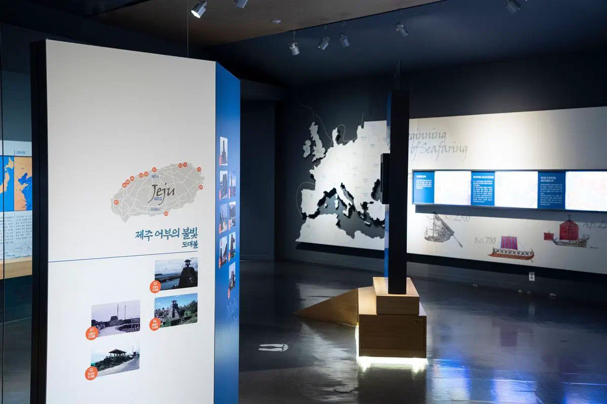 A gallery inside the museum, a map of ancient Mediterranean sea routes on one wall and a panel on Jeju's traditional dotaebul beacon towers on another