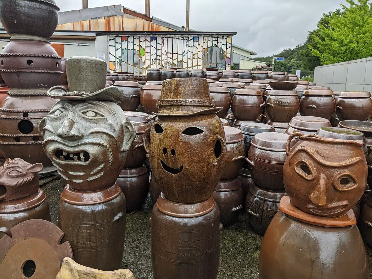 Close-up of unglazed Korean onggi jars in varying sizes, showing the textured clay surface