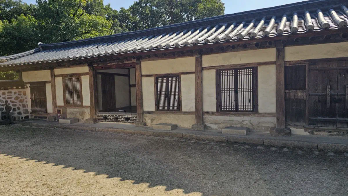 The low tiled-roof tomb keeper's house at Seooreung, white plaster walls above a fieldstone base