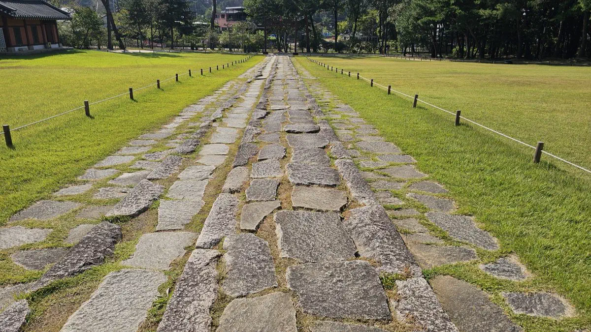 The worn stone path laid between two strips of grass leading to a ritual hall at Seooreung