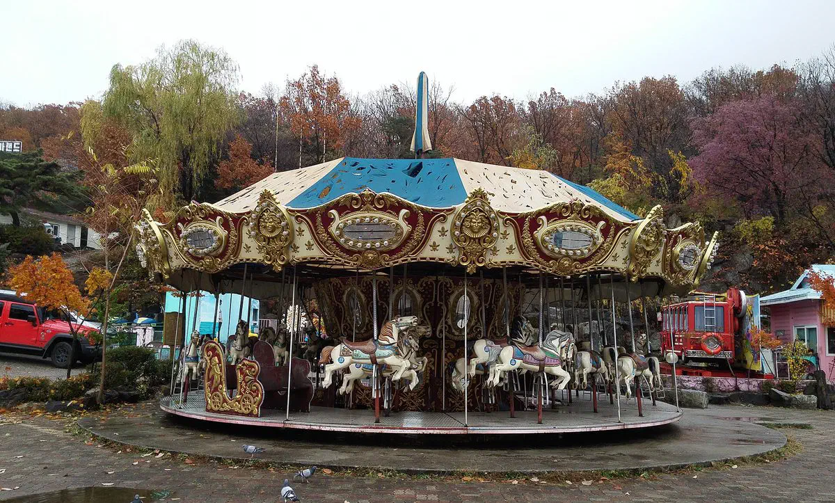 A weathered, disused horse carousel with a torn tarp roof at Yongma Land, an amusement park in eastern Seoul closed since 2011 but never demolished